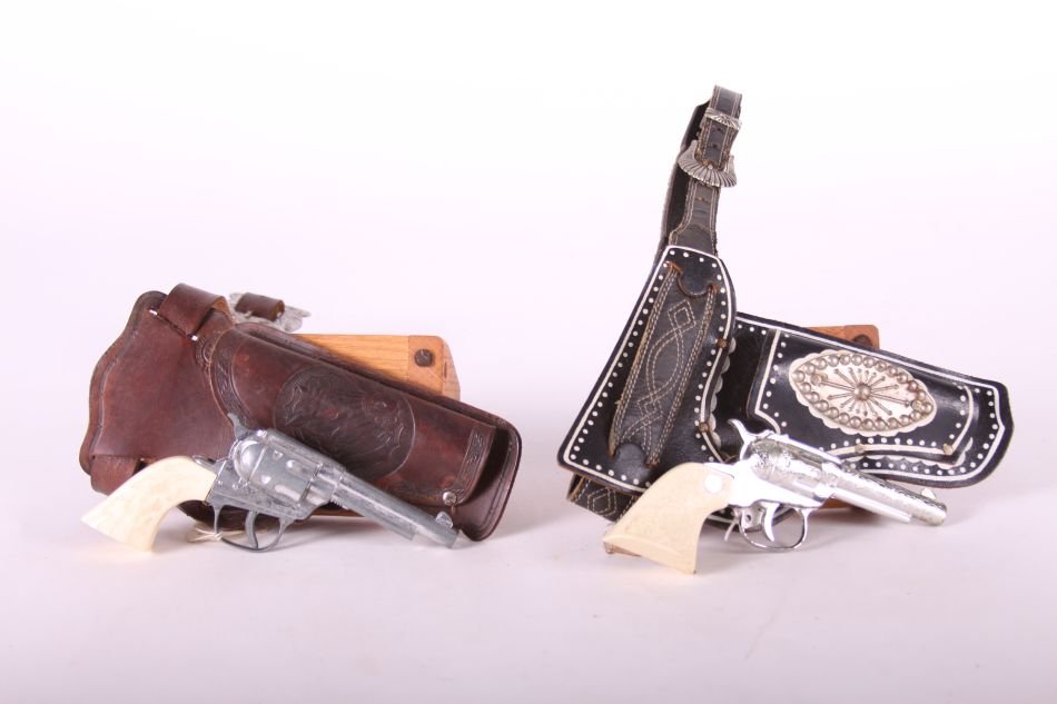 Lot of Two Cap Guns by Unknown Maker, One Top Gun Jr.,: Lot of Two Cap Guns by Unknown Maker, One Top Gun Jr., Die Cast, White Grips, One No Name, Die Cast, White Indian Head Grips, w/ Black Leather Holster and Belt and Brown Leather Holster and Belt