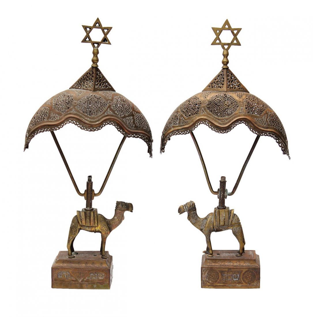Set of lamps for light. Damascus work. Israel, 20th: Important Judaica Pair of lamps for light on Shabbat, seems to be the work of the artist Avraham bar Adon. Moulded brass, engraved, bent, and sawn. Rectangular base, upon which sits a camel, with engr