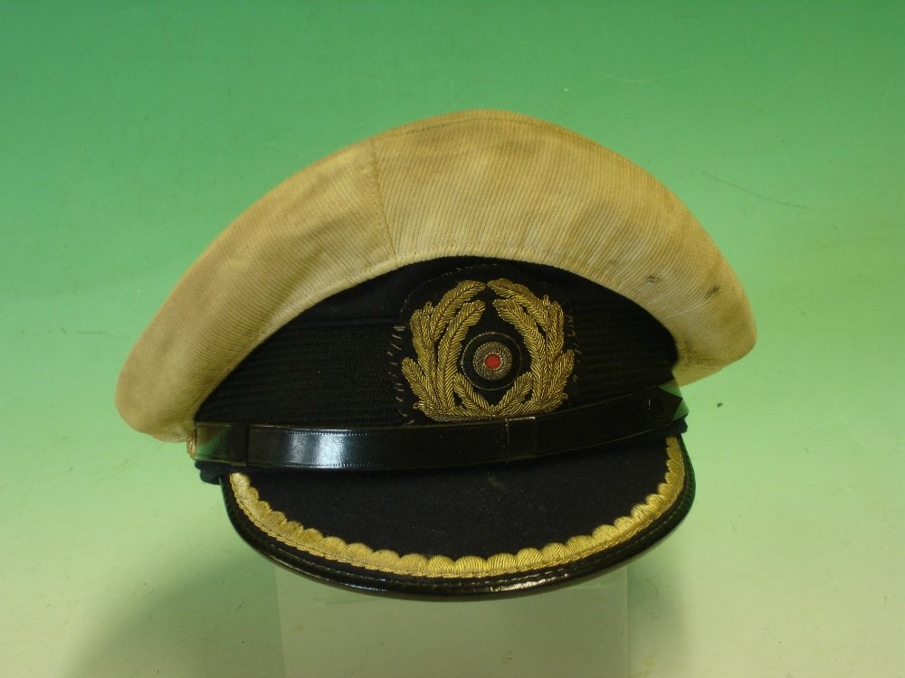 A Third Reich Naval Officer’s Peaked Cap: A Third Reich Naval Officer’s Peaked Cap For a Leautnant-zur-zee with easily removable Italian Navy type white cover. Fine condition^ some age related colour fading to the lining^ minor oxidation to