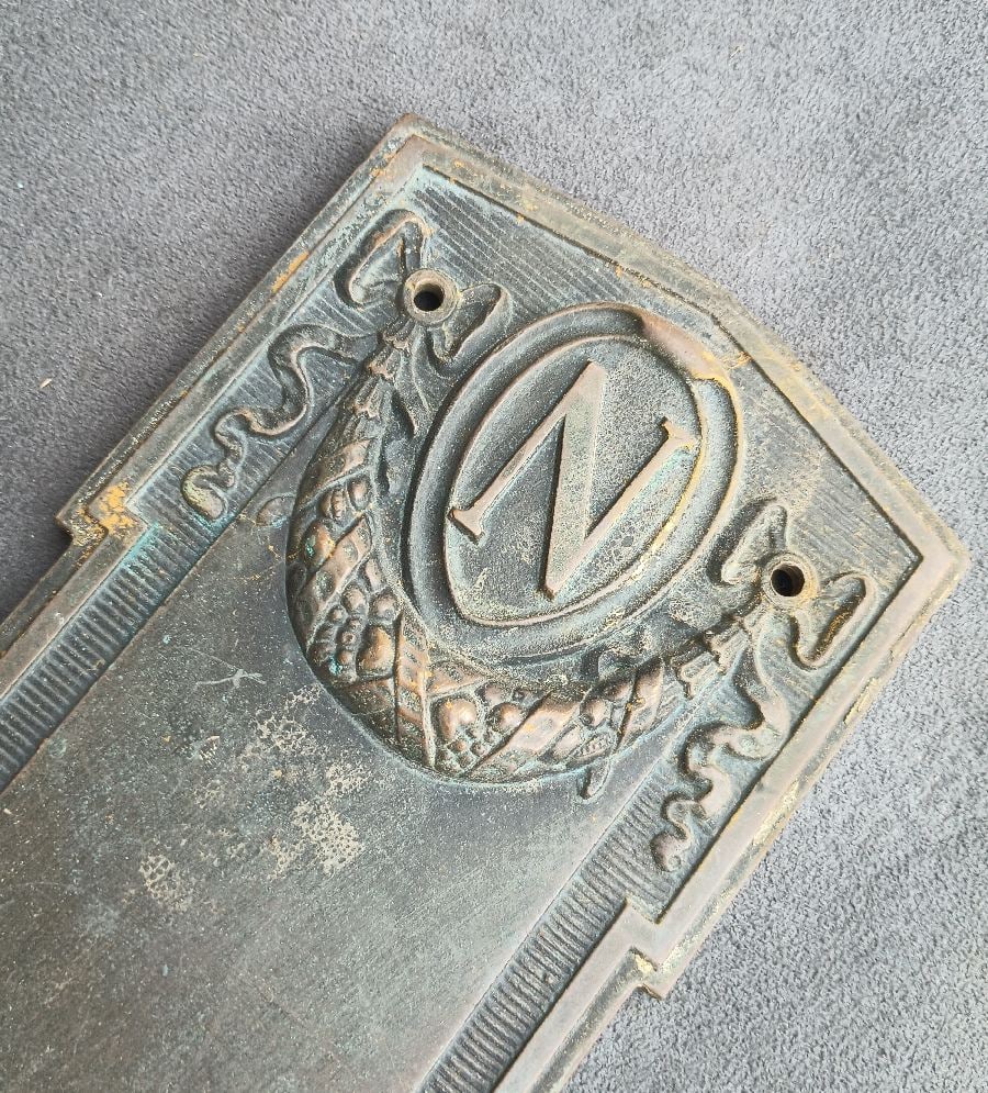 N for Napolean: If you know someone with a Napoleonic complex, look no further…bronze door plate measuring 18” x 3.5” and with a well-wrought N above a festoon with ribbons… for a friend, of c