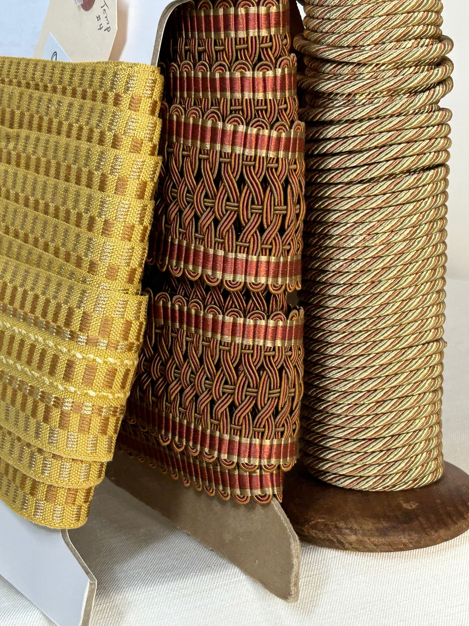 Three Bolts of Trimming: 30 yards of Scalamandre silk faced trimming .25” diameter in three colors, Jade, Gold and Rust, not sewn to tape. This trim is wrapped on a vintage Scalamandre Trim Department warp spool circa 1