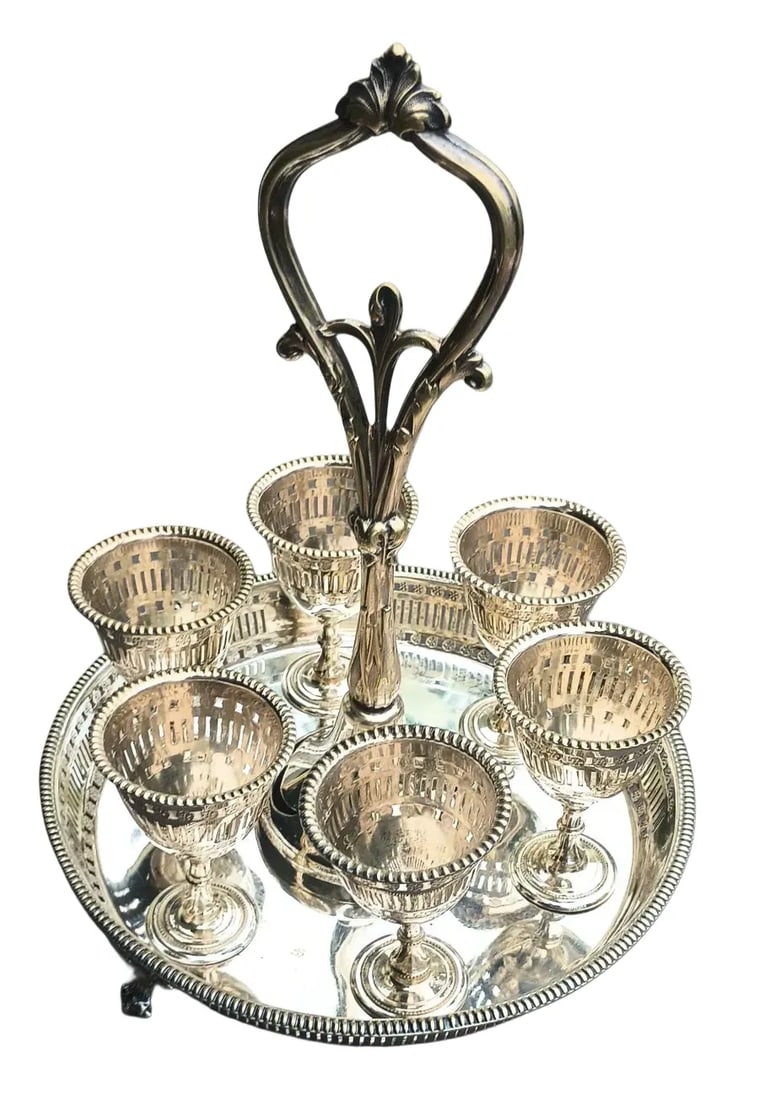 Egg Cups & Server: 8" in diameter and holding 6 egg cups on removable posts in a footed tray with reticulated border and centered with a 9" cast and engraved organic handle, a beautiful way to start your day! Signed on