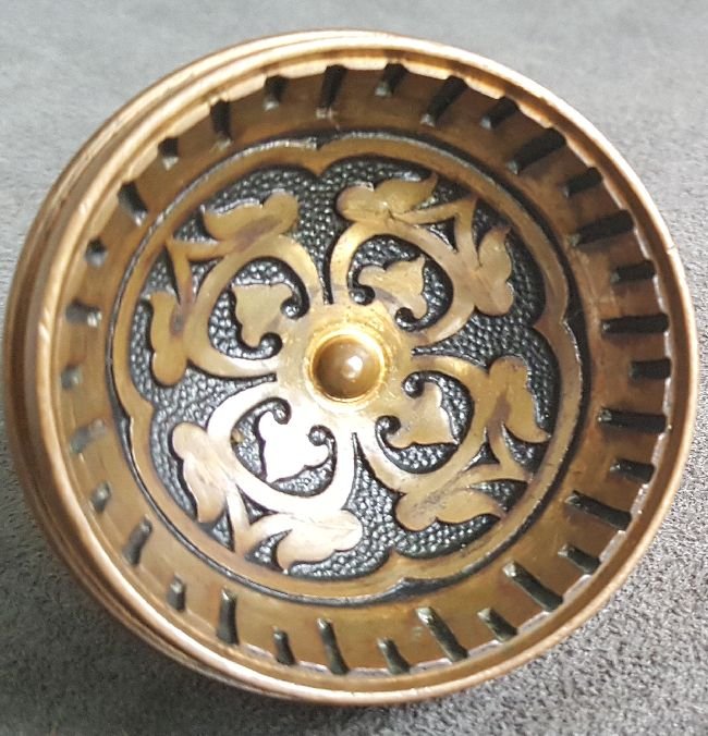 Fine and Rare 1870s Doorknob: A most unusual little doorknob: only 2” in diameter but with a cratered center showing strap work decoration and a button center, all surrounded by a notched and inverted ring…the reverse side is 