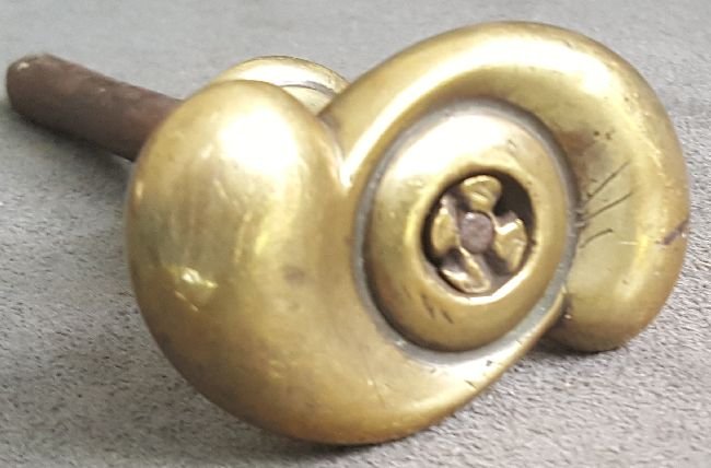 Unusual Early American Brass Knob: Solid cast brass knob dating from at least early 19th Century, in a form and style note seen before: first is the flattened S-shape on top of a turned and footed shank…then there is the little star-