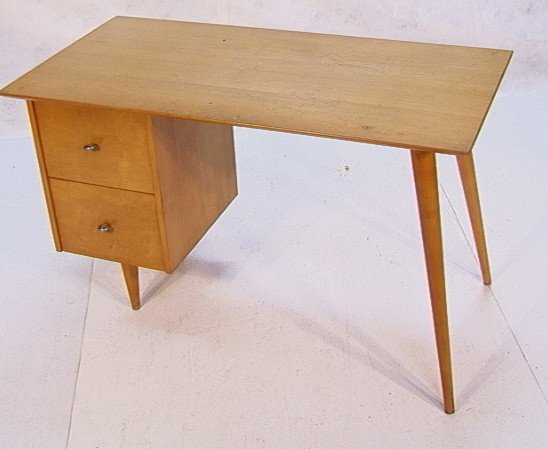 PAUL MCCOBB Blond Planner Group Desk: PAUL MCCOBB Blond Planner Group Desk. Two drawer form with tapered peg leg. Metal O drawer pulls. Unmarked. Dimensions: H: 29.5 inches: W: 48.5 inches: D: 24 inches Condition: Good Condition. Some rou