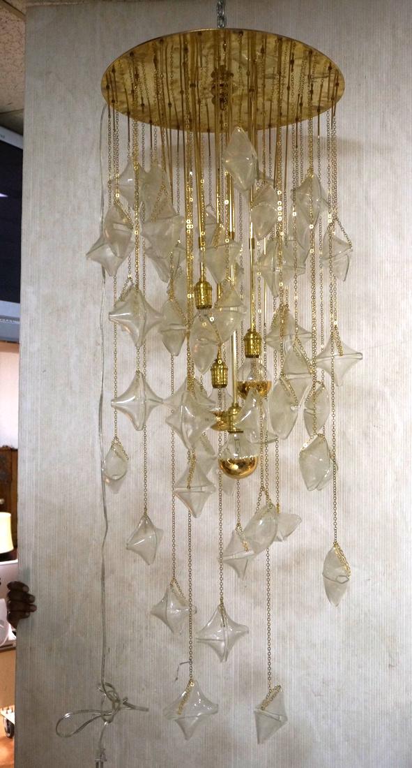 04 MILAN Italian Glass Dramatic Hanging Pendant C: 04 MILAN Italian Glass Dramatic Hanging Pendant Chandelier. MAZZEGA Hand Blown Folded Glass Elements hang from thin gold tone chains. Gold Tone Ceiling Plate. Fixture has four specialty bulbs. -- Dime