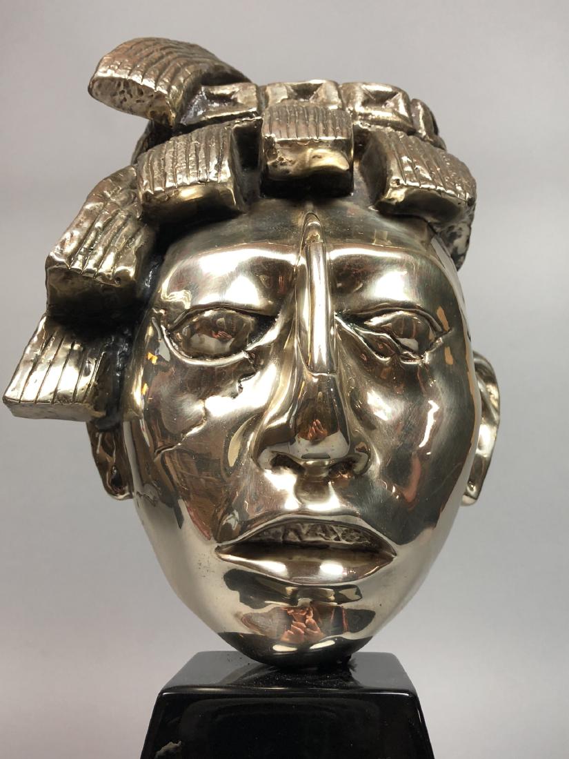 Pre Colombian Mask Table Sculpture. Silver coated: Pre Colombian Mask Table Sculpture. Silver coated on cast form. Ebonized trapezoidal base.-- Dimensions: H: 17.5 inches: W: 7.75 inches: D: 6.25 inches ---