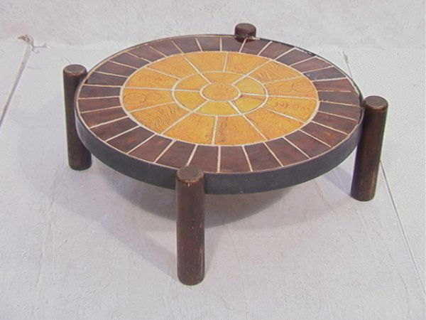 ROGER CAPRON Tile top cocktail table with wood leg: ROGER CAPRON Tile top cocktail table with wood legs. Dimensions: H: 13 inches: W: 37 inches Condition: Fair condition. Some losses to grout. Legs loose. Chip to leg. US Shipping charge: Pick up or shi
