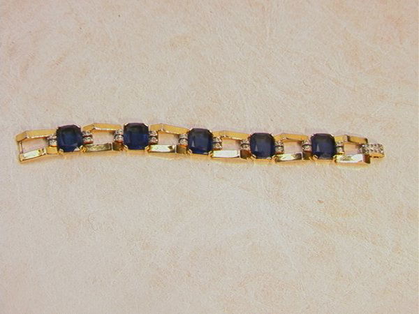 JOMAZ Lg Blue Stone ART DECO Link BRACELET. Five: JOMAZ Lg Blue Stone ART DECO Link BRACELET. Five Cushion "Sapphires" with clear Rhinestone accents on ART DECO Gold Links. Signed JOMAZ. Dimensions: H: 7 inches Condition: Excellent condition. US Ship