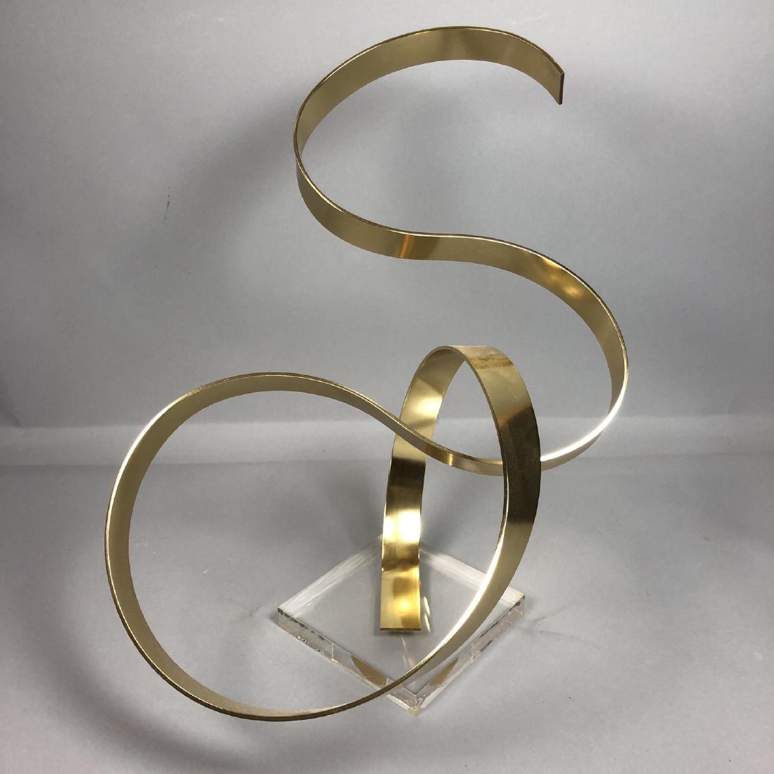 DAN MURPHY 1978 Table Sculpture. Gold Tone Metal: DAN MURPHY 1978 Table Sculpture. Gold Tone Metal and Lucite Ribbon Form Sculpture.-- Dimensions: H: 21 inches: W: 21 inches: D: 16 inches ---