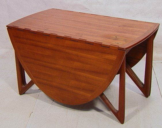 Danish Modern Hans Wegner Style Teak Dining Table.: Danish Modern Hans Wegner Style Teak Dining Table. Drop leaf oval table. Unique spider leg design. Dovetail style self hinge. Banded edges. Has danish furniture branded mark. Closed Size: 28inH x 50in