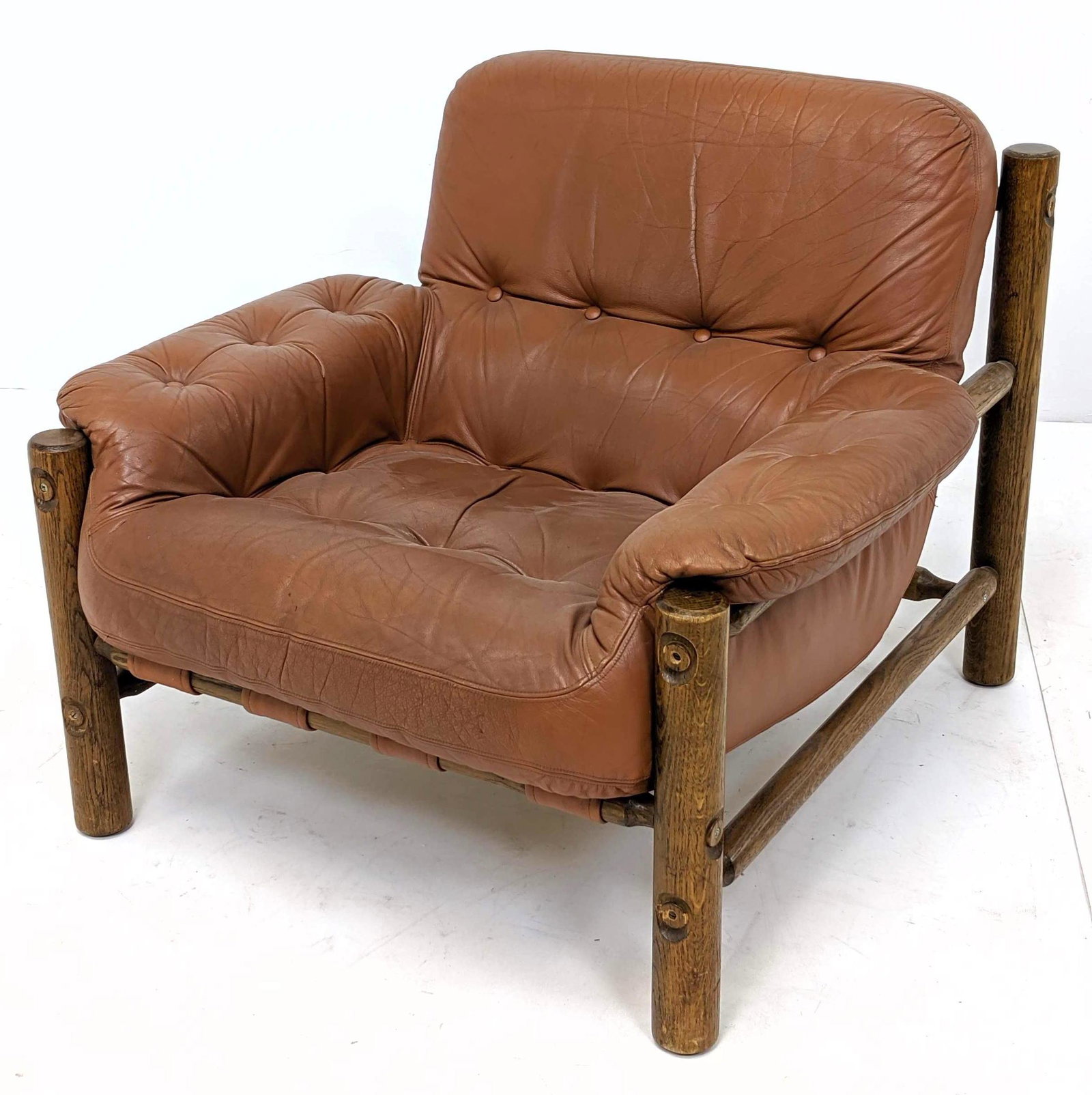 Modernist Thick Oak Column Leather Lounge Chair. Tufted: Modernist Thick Oak Column Leather Lounge Chair. Tufted slouchy light brown leather cushions. Canvas straps. Brazil style-- Dimensions: H: 27 inches: W: 34 inches: D: 36 inches ---