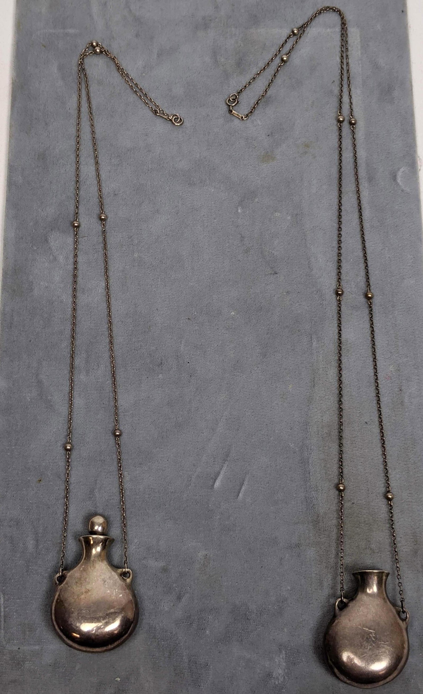 2pc ELSA PERETTI for TIFFANY & Co. Sterling Necklaces.: 2pc ELSA PERETTI for TIFFANY & Co. Sterling Necklaces. Modernist sculptural perfume bottle suspended on sterling chain with bead details. Marked Peretti Spain, one on bottle on chain. -- Dimensions: -