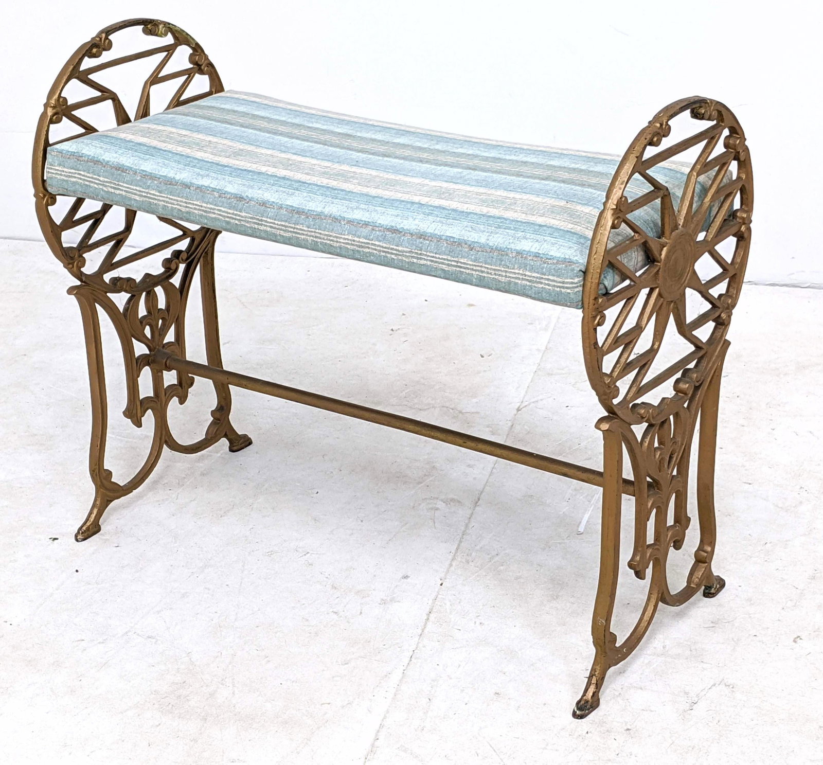 Ornate Gilt Iron Frame Bench. Circular with fleur de li: Ornate Gilt Iron Frame Bench. Circular with fleur de lis. Pale striped upholstery. -- Dimensions: H: 20.5 inches: W: 24.5 inches: D: 11.5 inches ---