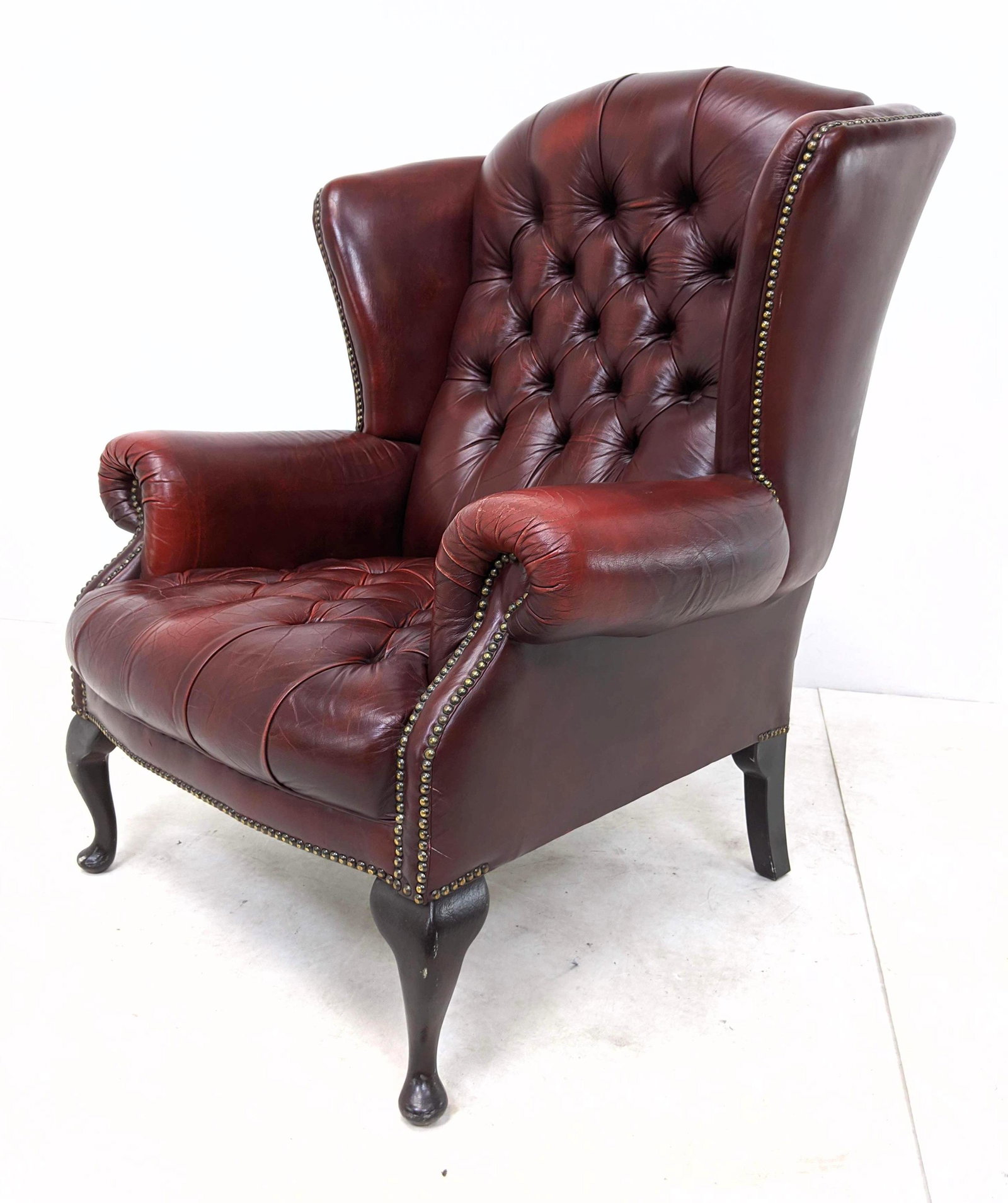 Burgundy Leather Chesterfield Tufted Wing Chair.: Burgundy Leather Tufted Wing Chair. Wood Queen Anne legs.-- Dimensions: H: 17 inches: W: 42 inches: D: 14.5 inches ---