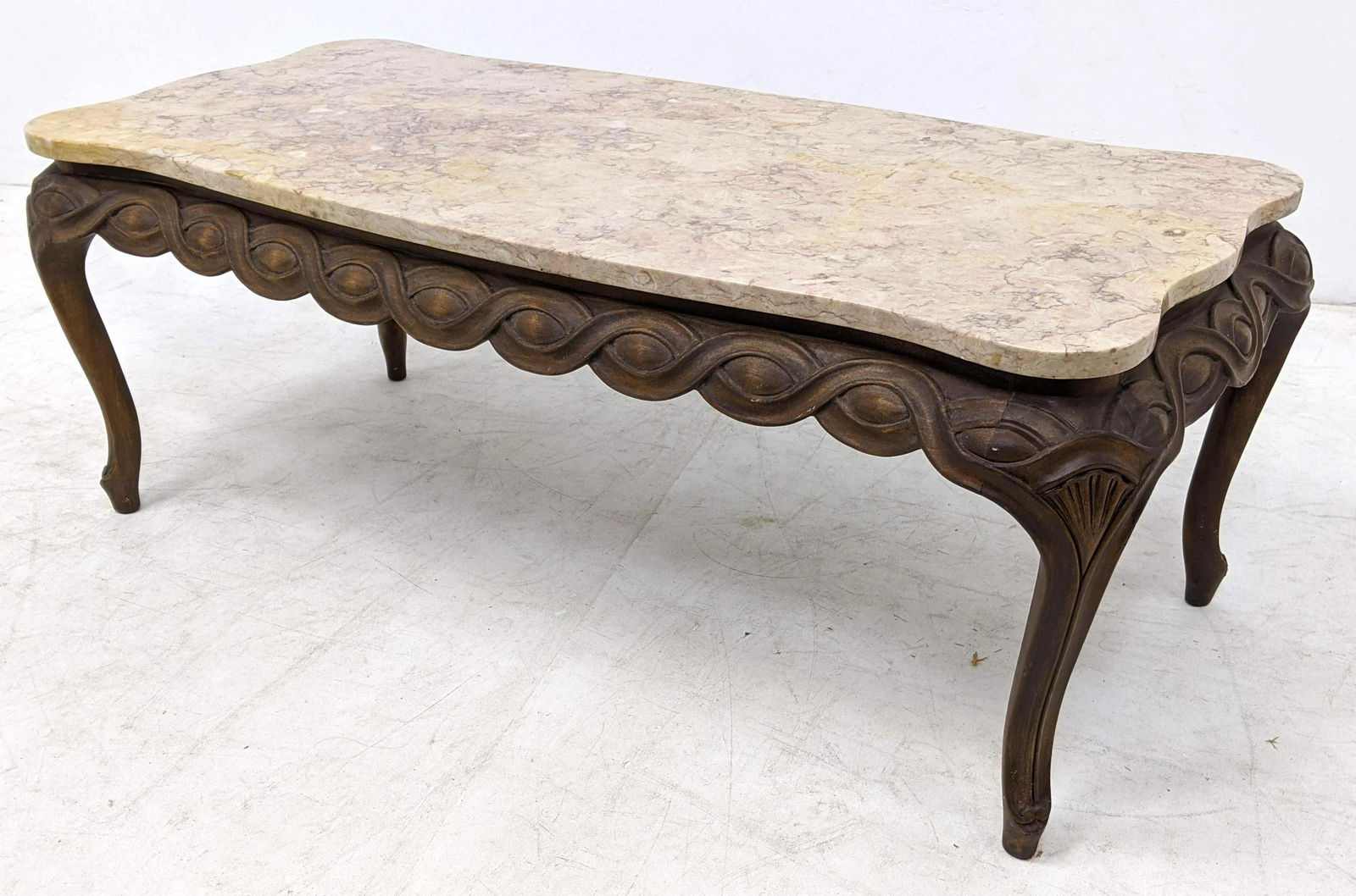 Wood and Marble Top Coffee Table. Ribbon Pattern carvin: Wood and Marble Top Coffee Table. Ribbon Pattern carving to wood base.-- Dimensions: H: 18 inches: W: 48 inches: D: 22 inches ---