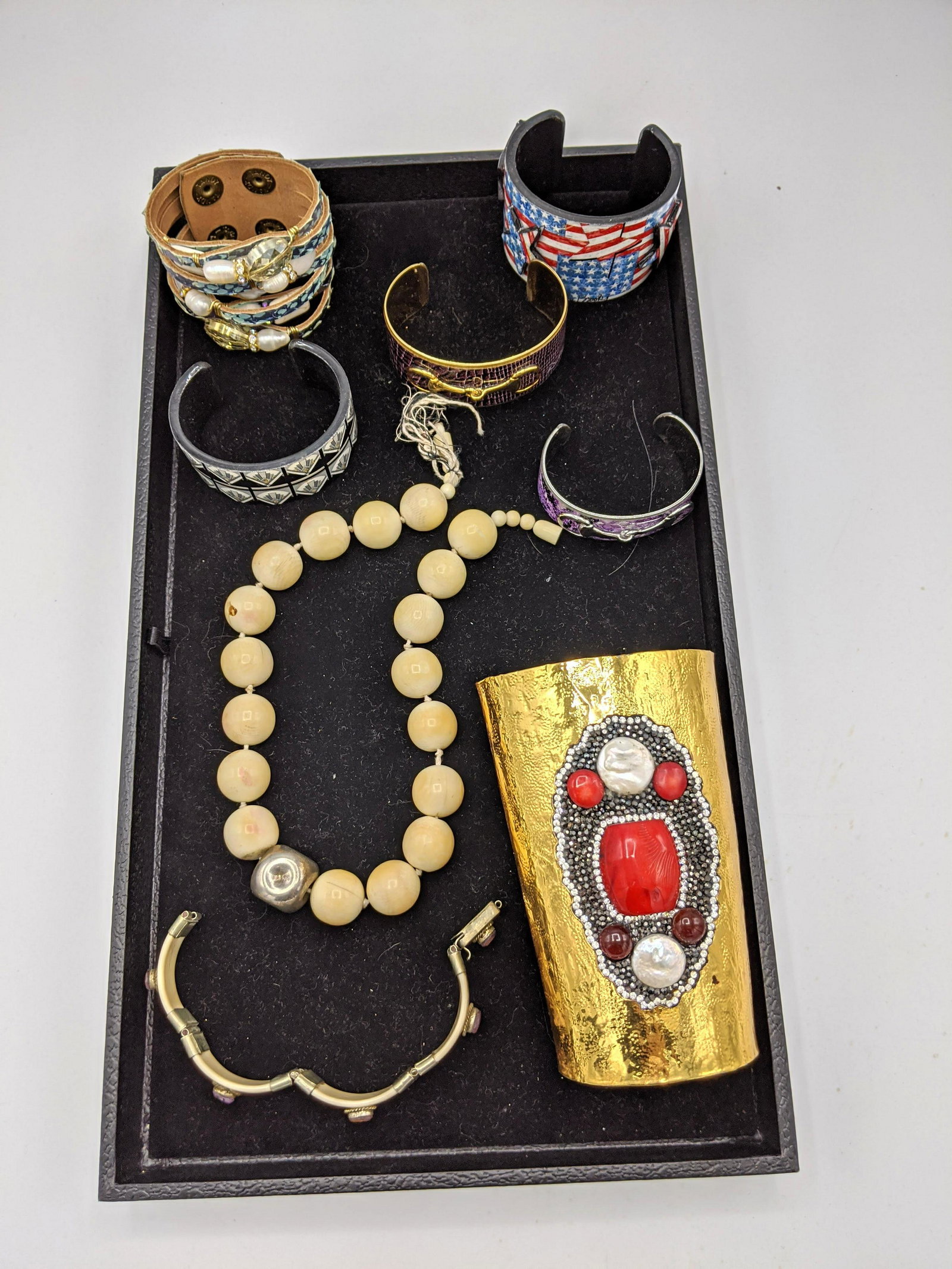 8pc Costume Jewelry Lot. Large cow bone bead necklace.: 8pc Costume Jewelry Lot. Large cow bone bead necklace. Large decorator gold tone cuff with crystal pearl details. Assorted costume bracelets. -- Dimensions: H: 4.75 inches: W: 3 inches: D: 2.5 inches 