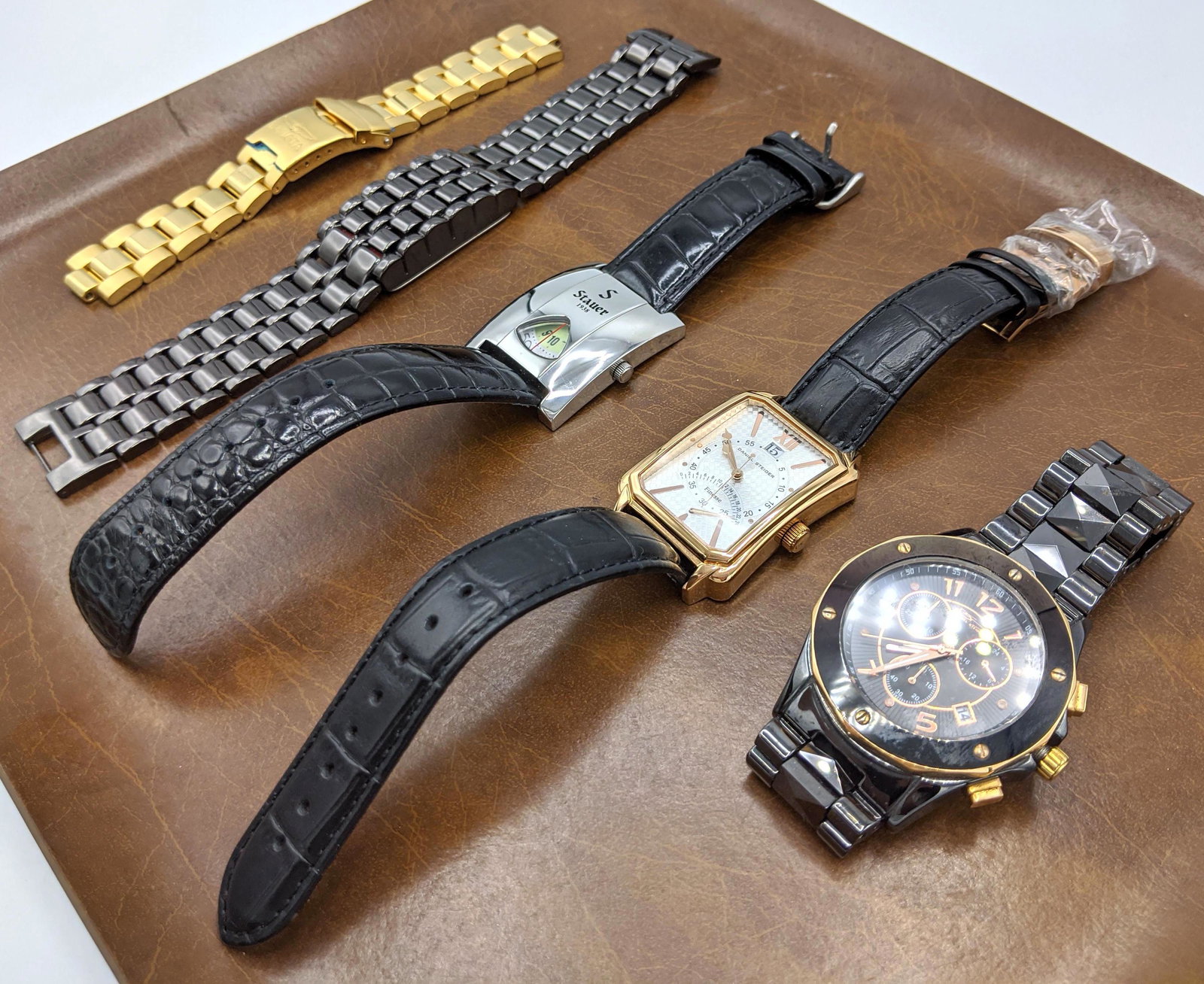 5pc Contemporary Men's Watch Lot. 2 by DANIEL STEIGER,: 5pc Contemporary Men's Watch Lot. 2 by DANIEL STEIGER, STAUER 1938, INVICTA gold tone band only. LED with gun metal band. (Four watches plus one band only.) -- Dimensions: : W: 1.25 inches --- US Ship