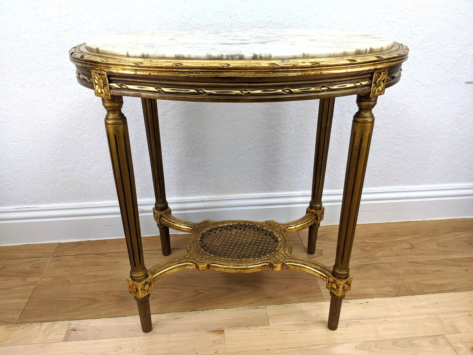 Oval Marble Top French Center Table. Lower caned shelf.: Oval Marble Top French Center Table. Lower caned shelf. Ribbon trim top. Reeded legs-- Dimensions: H: 30 inches: W: 30 inches: D: 21 inches ---