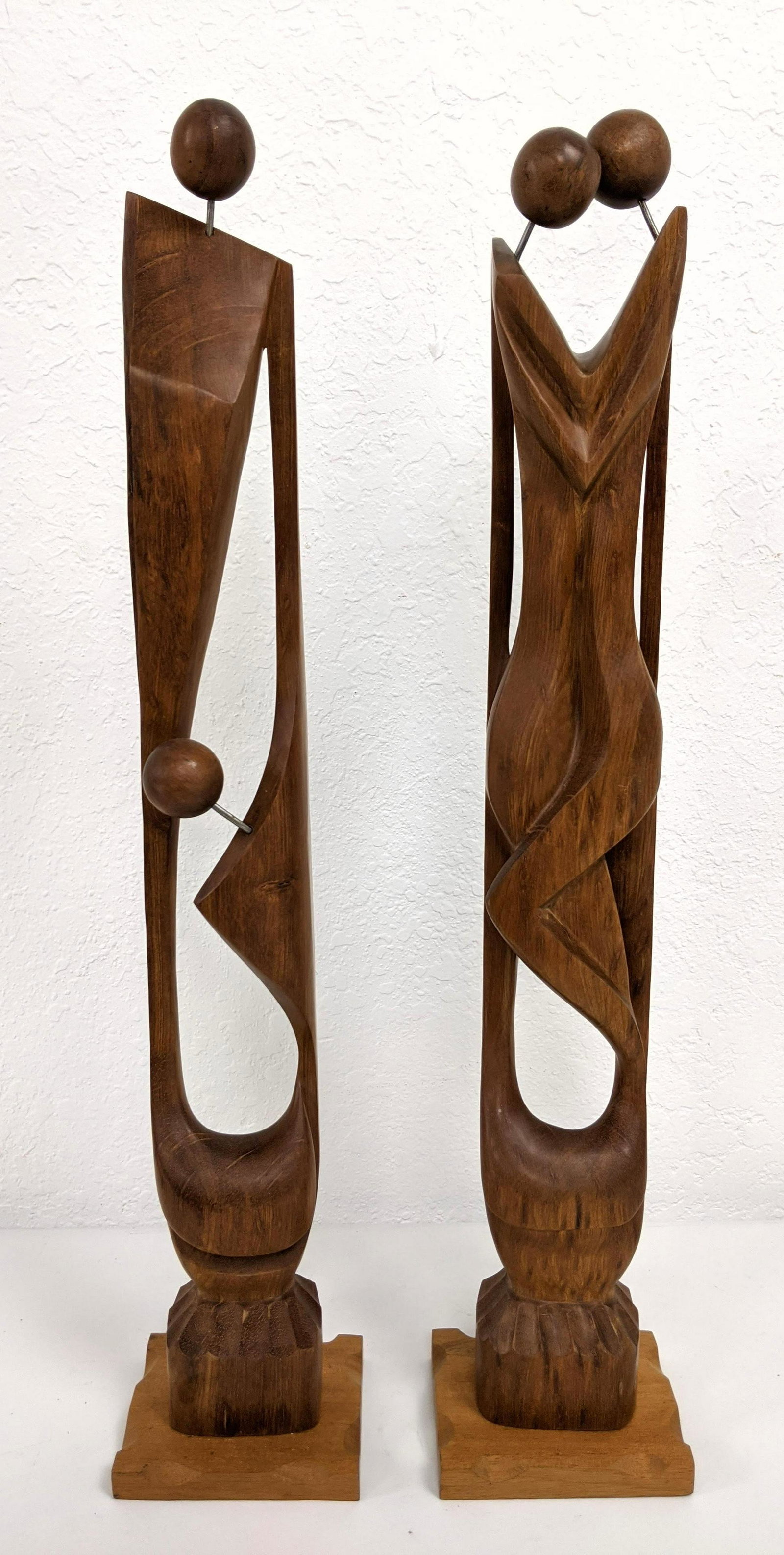 2pc Modernist Carved Wood Figural Statues Sculptures. M: 2pc Modernist Carved Wood Figural Statues Sculptures. Modern minimalist form of two couples with sphered heads. Not marked-- Dimensions: H: 24.5 inches: W: 4.5 inches: D: 4 inches ---