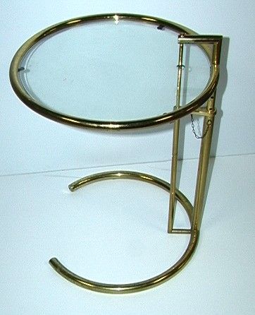 EILEEN GRAY E1027 ADJUSTABLE ROUND GLASS TOP TABLE: EILEEN GRAY E1027 ADJUSTABLE ROUND GLASS TOP TABLE. Adjustable height table in gold finish. Dimensions: H: 29 inches: W: 20.5 Condition: Wear Metal Finish. US Shipping charge: Pick up or shipping quot