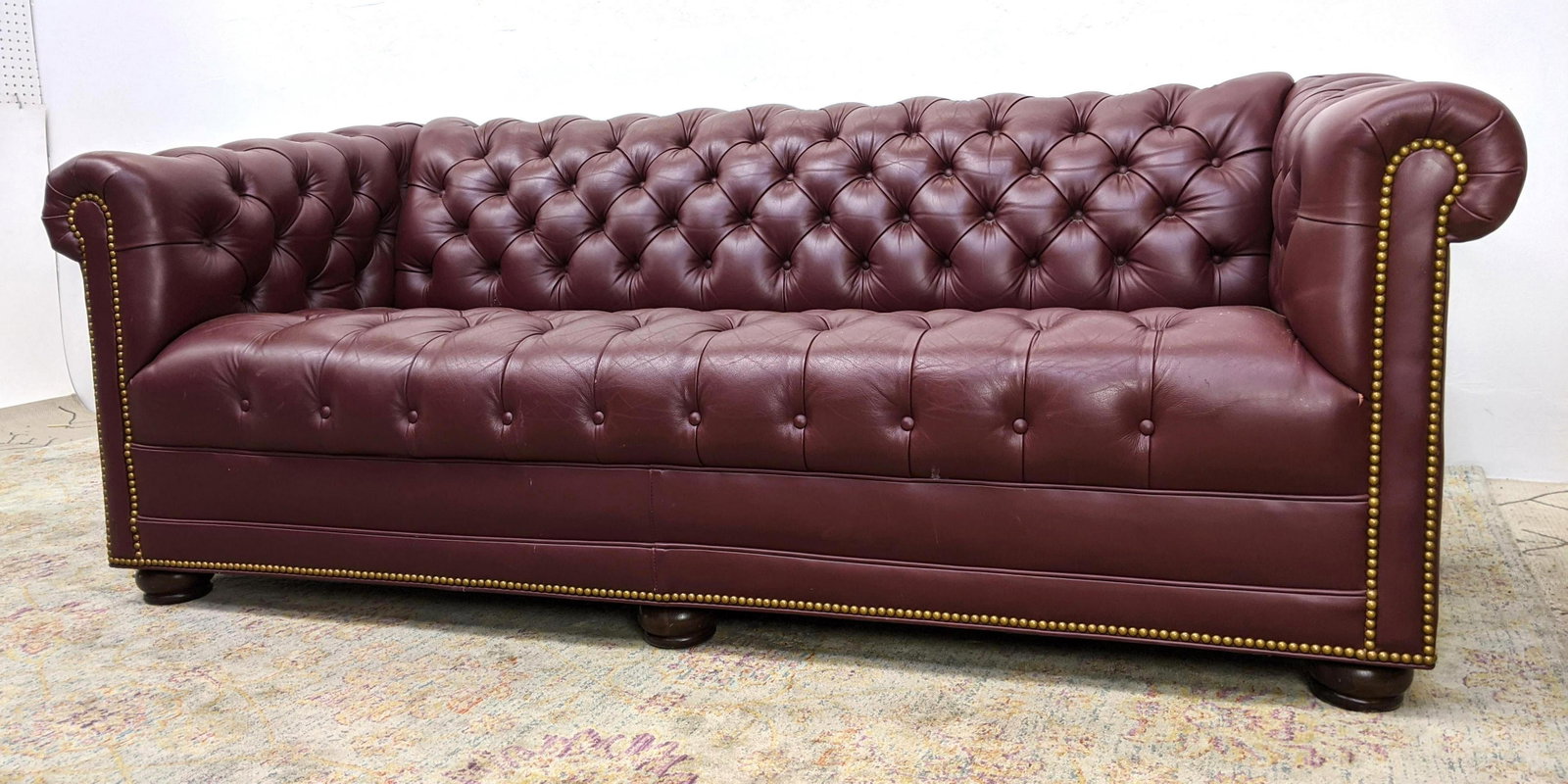 HANCOCK & MOORE Leather Chesterfield Sofa Couch. Madeir: HANCOCK & MOORE Leather Chesterfield Sofa Couch. Madeira Wine Color Leather with Nail stud trim details. Wood bun feet. Label. -- Dimensions: H: 29.5 inches: W: 74 inches: D: 34 inches ---