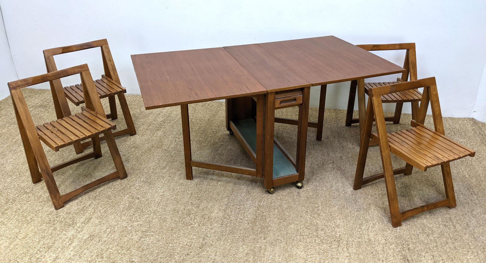 Mid Century Modern Drop Side Dining Set. Rolling Table: Mid Century Modern Drop Side Dining Set. Rolling Table and 4 Folding Chairs. Two 25" drops. Chairs store under table behind tambour door.-- Dimensions: H: 48 inches: W: 18 inches: D: 17 inches ---