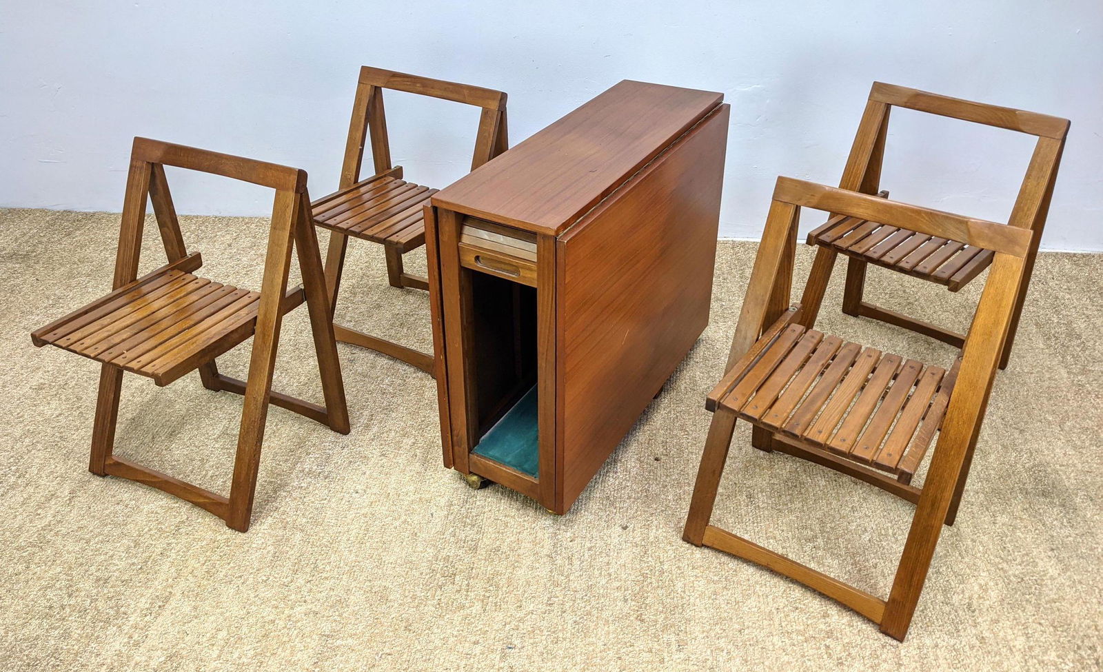 Modern Drop Side Portable Dining Table & Chairs Unit. S: Modern Drop Side Portable Dining Table & Chairs Unit. Single unit features large dining table and 4 hidden folding chairs. Tambour door compartment reveals 4 slat seat folding chairs. On casters. Dani