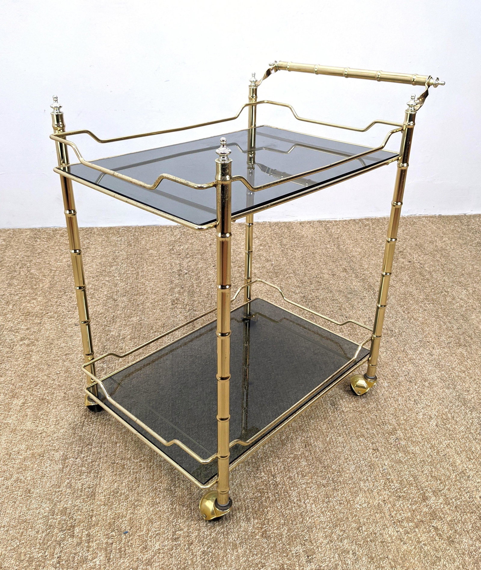 Gold Tone Bamboo Frame Rolling Serving Bar Cart. Two Sm: Gold Tone Bamboo Frame Rolling Serving Bar Cart. Two Smoked Glass Shelves. Decorative finials and rails. -- Dimensions: H: 32 inches: W: 28 inches: D: 17 inches ---