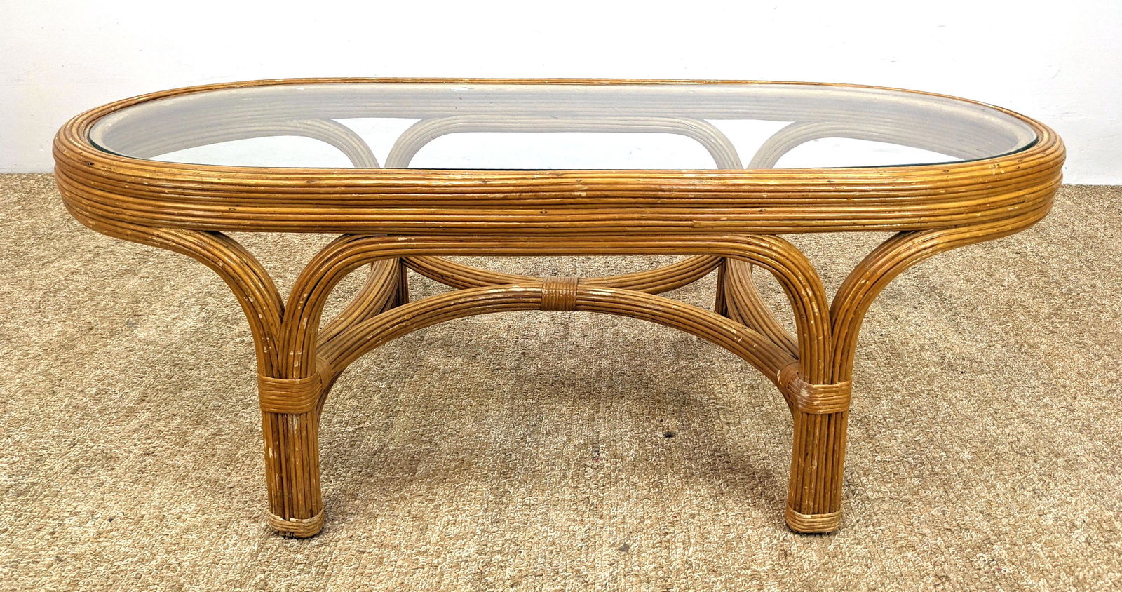 Pencil Reed Glass Top Modernist Coffee Table. Racetrack: Pencil Reed Glass Top Modernist Coffee Table. Racetrack form with wrapped reed rattan frame. -- Dimensions: H: 16 inches: W: 48 inches: D: 23 inches ---