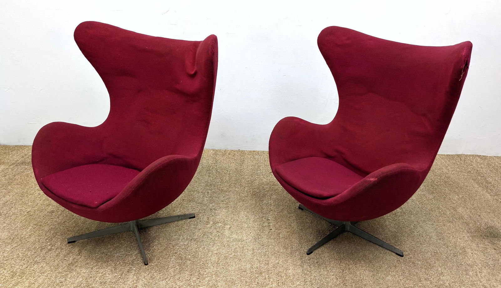 Pr FRITZ HANSEN Iconic Egg Lounge Chairs. Wine color. U: Pr FRITZ HANSEN Iconic Egg Lounge Chairs. Wine color. Upholstered forms on metal pedestal bases. Marked FH Denmark. All Original. -- Dimensions: H: 43 inches: W: 36 inches: D: 29 inches ---