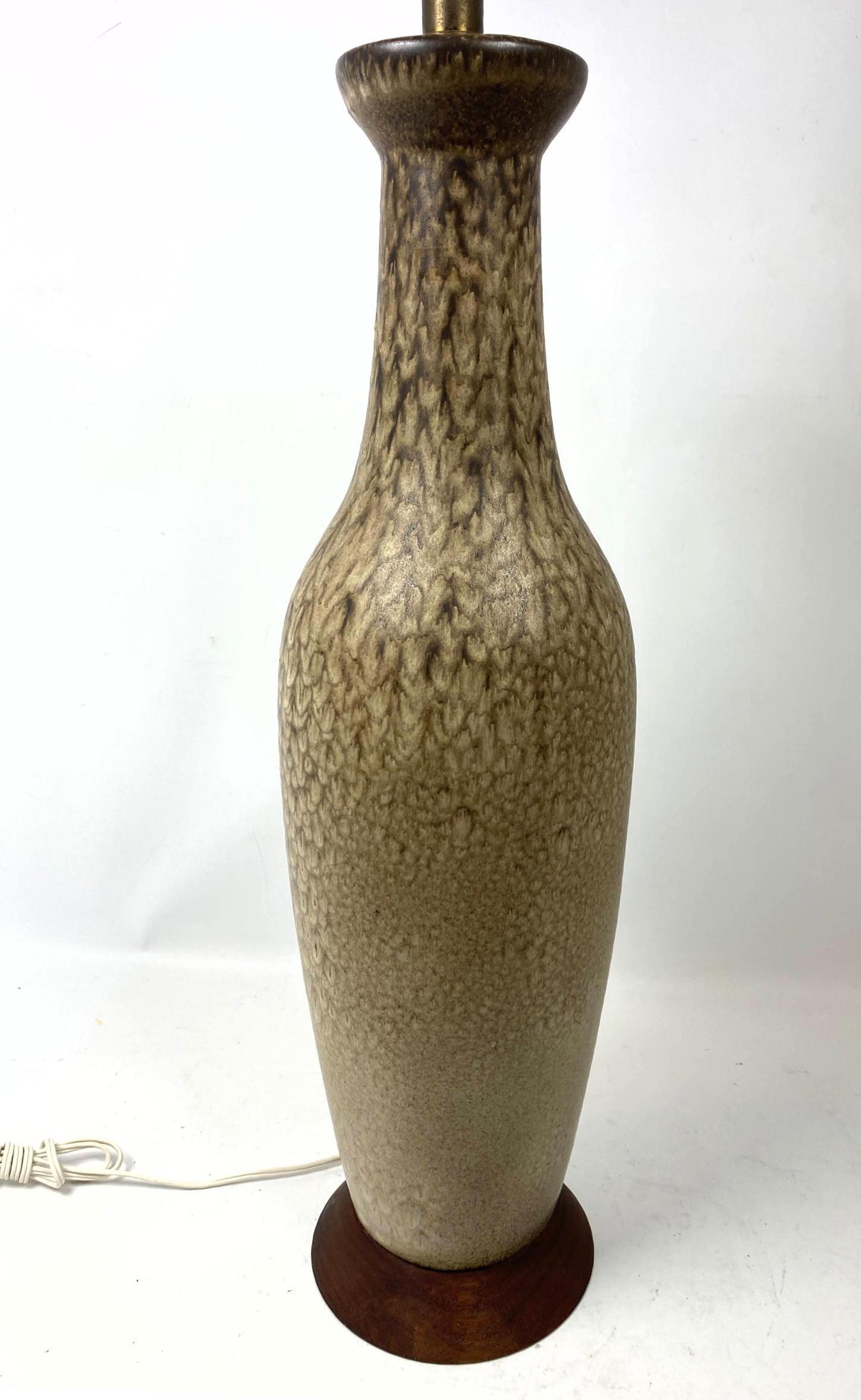 Tall Modernist Glazed pottery Table Lamp. Attributed to: Tall Modernist Glazed pottery Table Lamp. Attributed to Design Technics. Bottle form vessel with textured neutral glazes. Walnut trim-- Dimensions: H: 37 inches: W: 7 inches: D: 7 inches ---