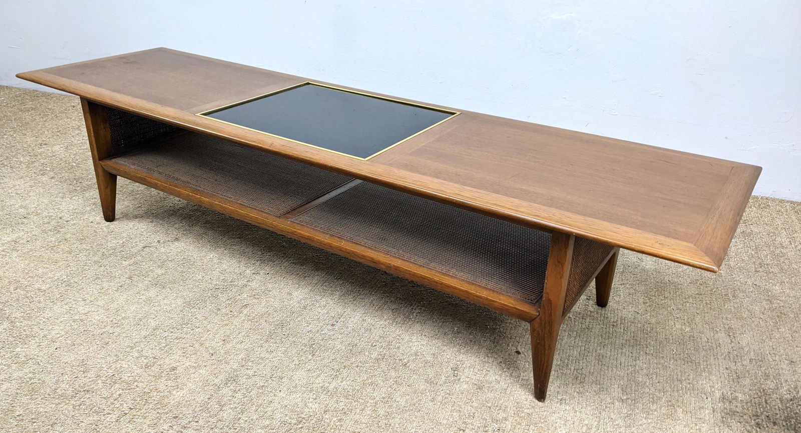 Modernist Coffee Table. Inset black glass element to to: Modernist Coffee Table. Inset black glass element to top. Woven Sides and Lower Level.-- Dimensions: H: 15 inches: W: 72 inches: D: 20 inches ---