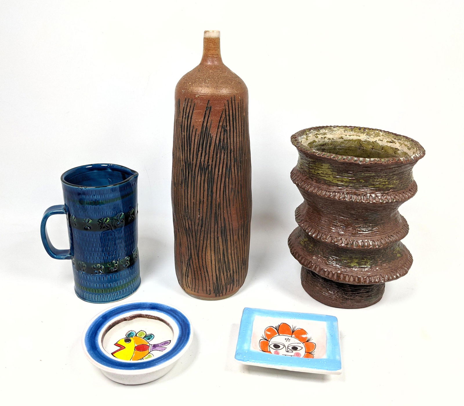 5pc Lot Mid Century Pottery. In Small Dishes. Includes: 5pc Lot Mid Century Pottery. In Small Dishes. Includes 2pcs DeSIMONE Small Dishes. Italian Raymor style Pitcher. Two Glazed Modernist Vases. -- Dimensions: H: 14.5 inches: W: 4.5 inches: D: 4.5 inches