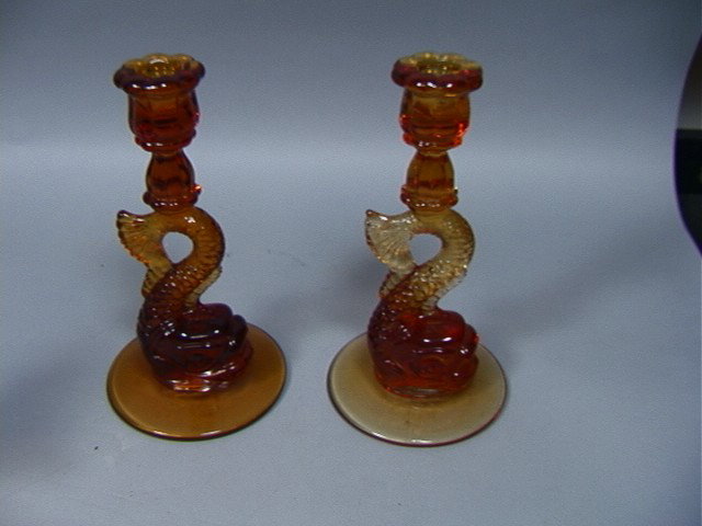 Pair Amber Glass Dolphin Candlesticks.: Pair Amber Glass Dolphin Candlesticks.-- Dimensions: H: 9 inches: W: 4.5 inches --- Condition (General): Good condition. Please contact us with specific questions about condition, not visible in the p