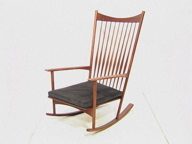 Danish Modern High Back Teak Rocker Rocking Chair: Danish Modern High Back Teak Rocker Rocking Chair. Tall Spindle Back Rocker. Paddle Arms with Thru Tenon Supports. Sloped Arched Back Rail and Skirt. Bowed Spindles. Loose Cushion Seat. Unmarked.-- Di