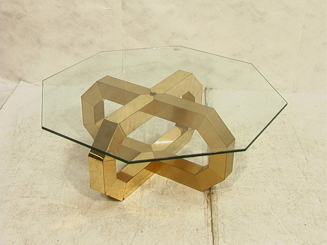 Modernist Evans Style Coffee Cocktail Table. Oct: Modernist Evans Style Coffee Cocktail Table. Octagon glass on brushed brass base. 1/2 inch glass.-- Dimensions: H: 15.5 inches: W: 42 inches --- Condition (General): Some rust spots. Please contact us