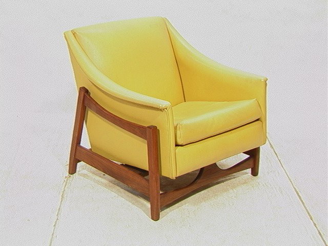 American Modern Walnut Rocking Lounge Chair. Yel: American Modern Walnut Rocking Lounge Chair. Yellow vinyl upholstery. Unmarked-- Dimensions: H: 30 inches: W: 31 inches: D: 32 inches --- Condition (General): sagging to support straps. Nailed repair 