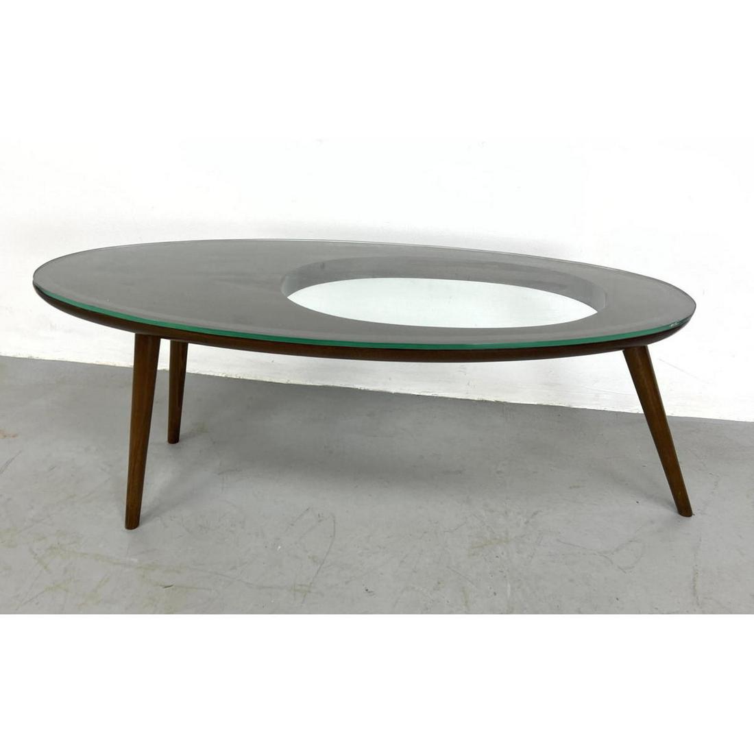 Italian Modern Style Coffee Table. Gio Ponti style. Ell: Italian Modern Style Coffee Table. Gio Ponti style. Elliptical Wood Coffee Table. Cut out detail to top. Glass Top. Dimensions: H: 18 inches: W: 44 inches: D: 18 inches ---