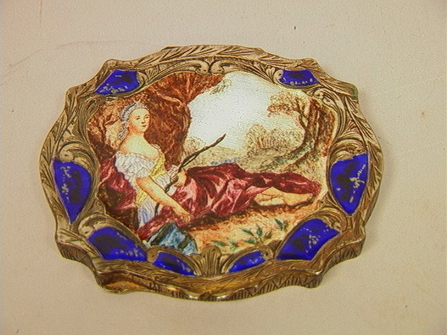 800 Silver Enamel Compact. Enamel Decoration of: 800 Silver Enamel Compact. Enamel Decoration of Reclining Woman on Heavily Engraved Body. Mirrored Interior. -- Dimensions: H: 2.5 inches: W: 3.25 inches--- Weight: 3.23 Troy ozs. ---- --- Condition (