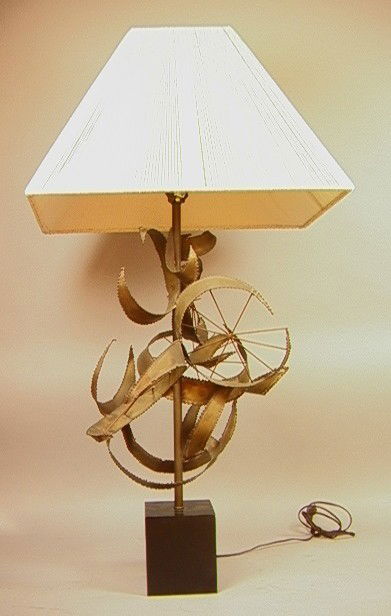 PAUL EVANS Style Welded Metal Brass Table Lamp. W: PAUL EVANS Style Welded Metal Brass Table Lamp. Welded crescents with spokes on metal rod. Black Metal Base. -- Dimensions: H: 41 inches: W: 15 inches --- Condition (General): Very Good Condition. Min