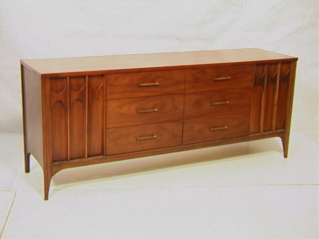 KENT COFFEY American Modern Walnut Credenza. Arch: KENT COFFEY American Modern Walnut Credenza. Arched Skirt. Six Drawers & 2 Doors. Metal Pulls.-- Dimensions: H: 31 inches: D: 20 inches: L: 77.5 inches --- Condition (General): Little chip to corner. 