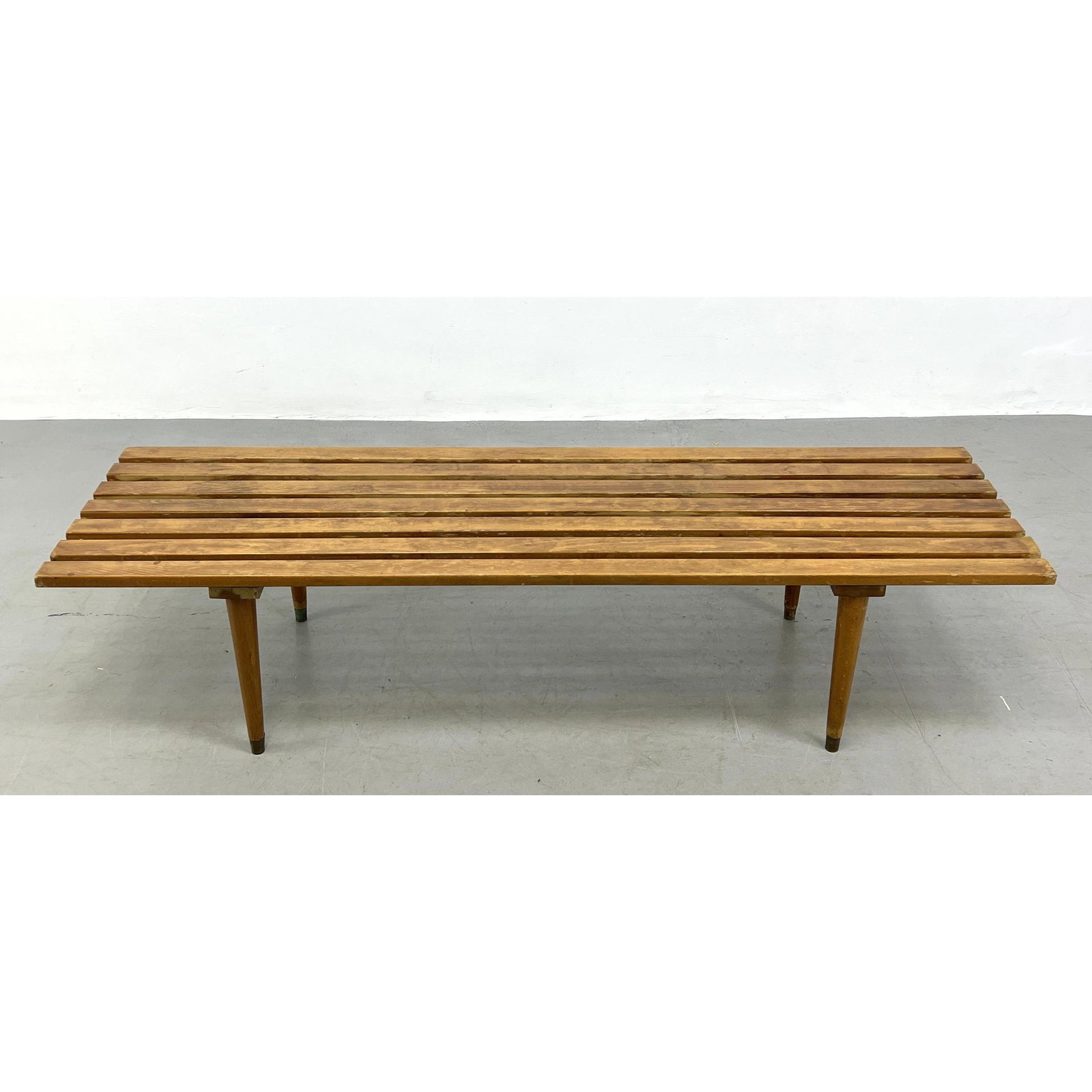 Modernist Slat Bench. Tapered Wood Legs with metal caps.: Modernist Slat Bench. Tapered Wood Legs with metal caps. Dimensions: H: 14 inches: W: 60 inches: D: 17.5 inches ---