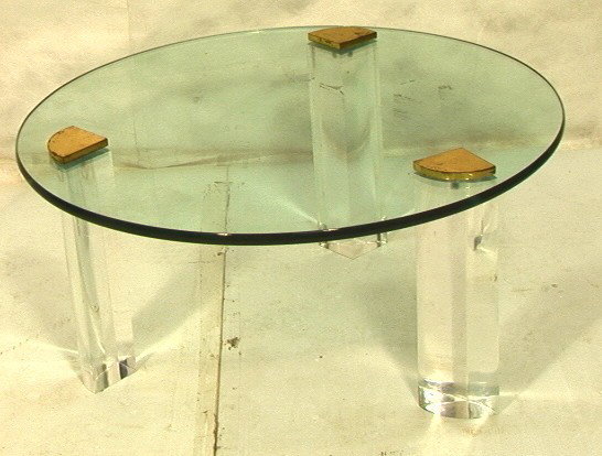 70Õs Modern Glass Top Coffee Cocktail Table. Luc: 70Õs Modern Glass Top Coffee Cocktail Table. Lucite legs with brass caps.-- Dimensions: H: 16 inches: W: 35.75 inches --- Condition (General): Brass caps are missing some plating. Tape marks on glass