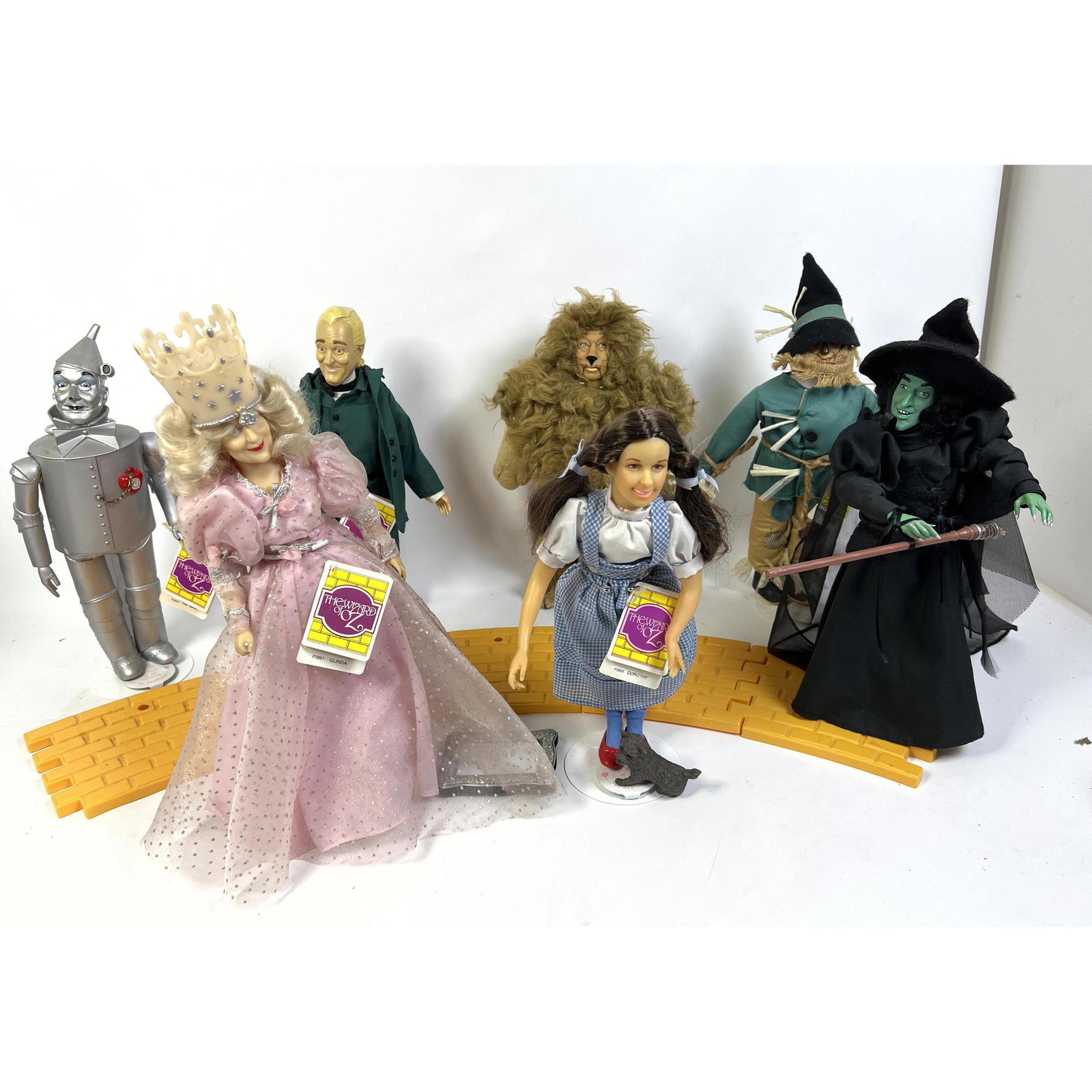 8pc PRESENTS Hamilton Gifts "Wizard of Oz" Dolls and Yellow Brick Road. Dorothy, Glinda. Tin Man. Sc: 8pc PRESENTS Hamilton Gifts "Wizard of Oz" Dolls and Yellow Brick Road. Dorothy, Glinda. Tin Man. Scarecrow, Cowardly Lion, Oz and Esmerelda the Witch. Some with original tags. Dimensions: H: 16 inche
