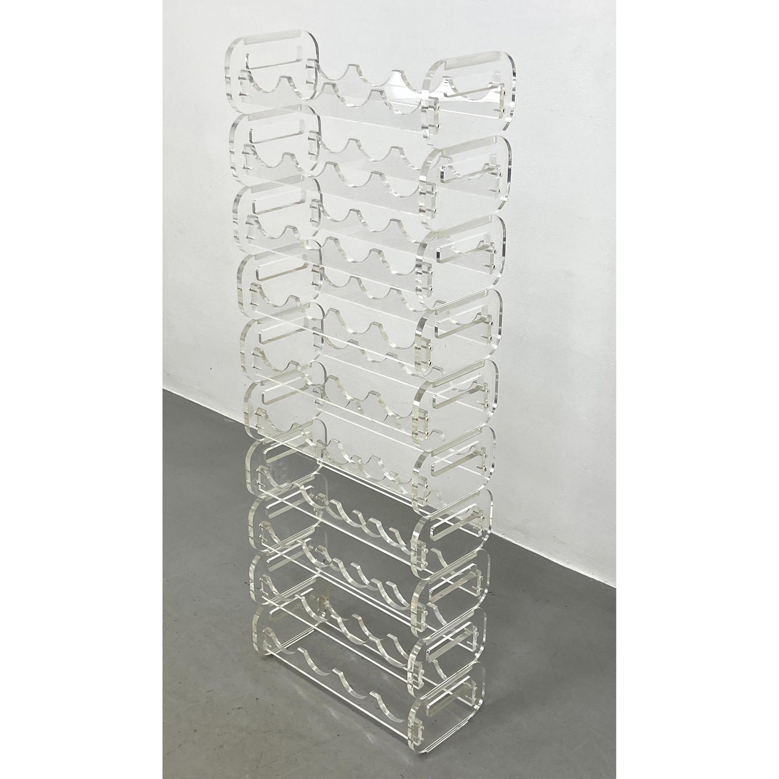 Stackable Lucite Wine Racks. Interchangeable bottle holder Lucite shelf. Each unit with thick sides: Stackable Lucite Wine Racks. Interchangeable bottle holder Lucite shelf. Each unit with thick sides and handles for transport. Dimensions: H: 47.5 inches: W: 17 inches: D: 8 inches ---