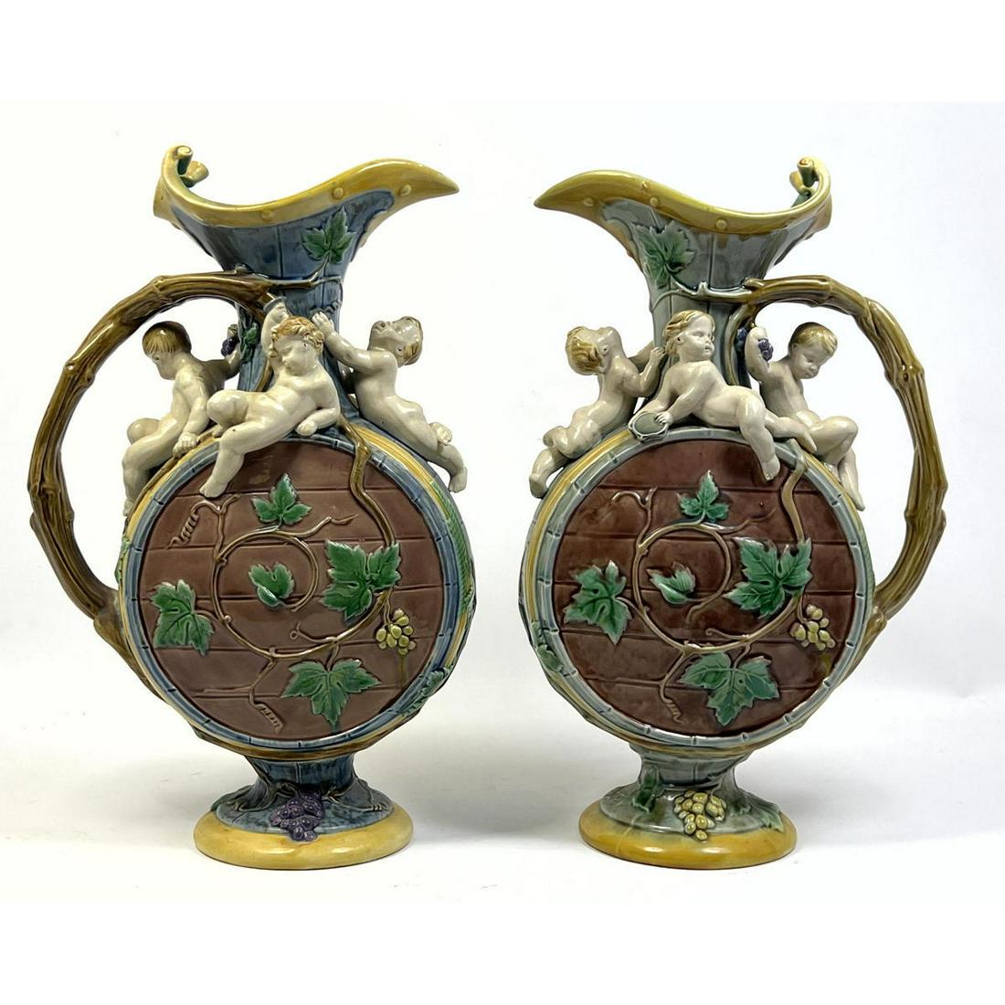 Pair MINTON Majolica Harvest ewers. H Protat for Minton. Figural 3D Cherubs and Faux bamboo handles.: Pair MINTON Majolica Harvest ewers. H Protat for Minton. Figural 3D Cherubs and Faux bamboo handles. Marked Minton 9001. Dimensions: H: 14.5 inches: W: 10 inches: D: 4 inches --- Uniques is closed for