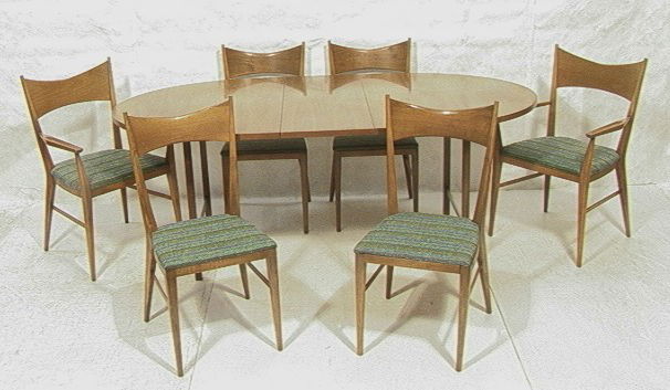 Paul McCobb Calvin Dining Set. Table and 6 Chair: Paul McCobb Calvin Dining Set. Table and 6 Chairs. Oval table, Two Arm Chairs, and 4 Side Chairs. Two 15in leaves-- Dimensions: H: 29 inches: W: 62 inches --- Condition (General): one stretcher has gl