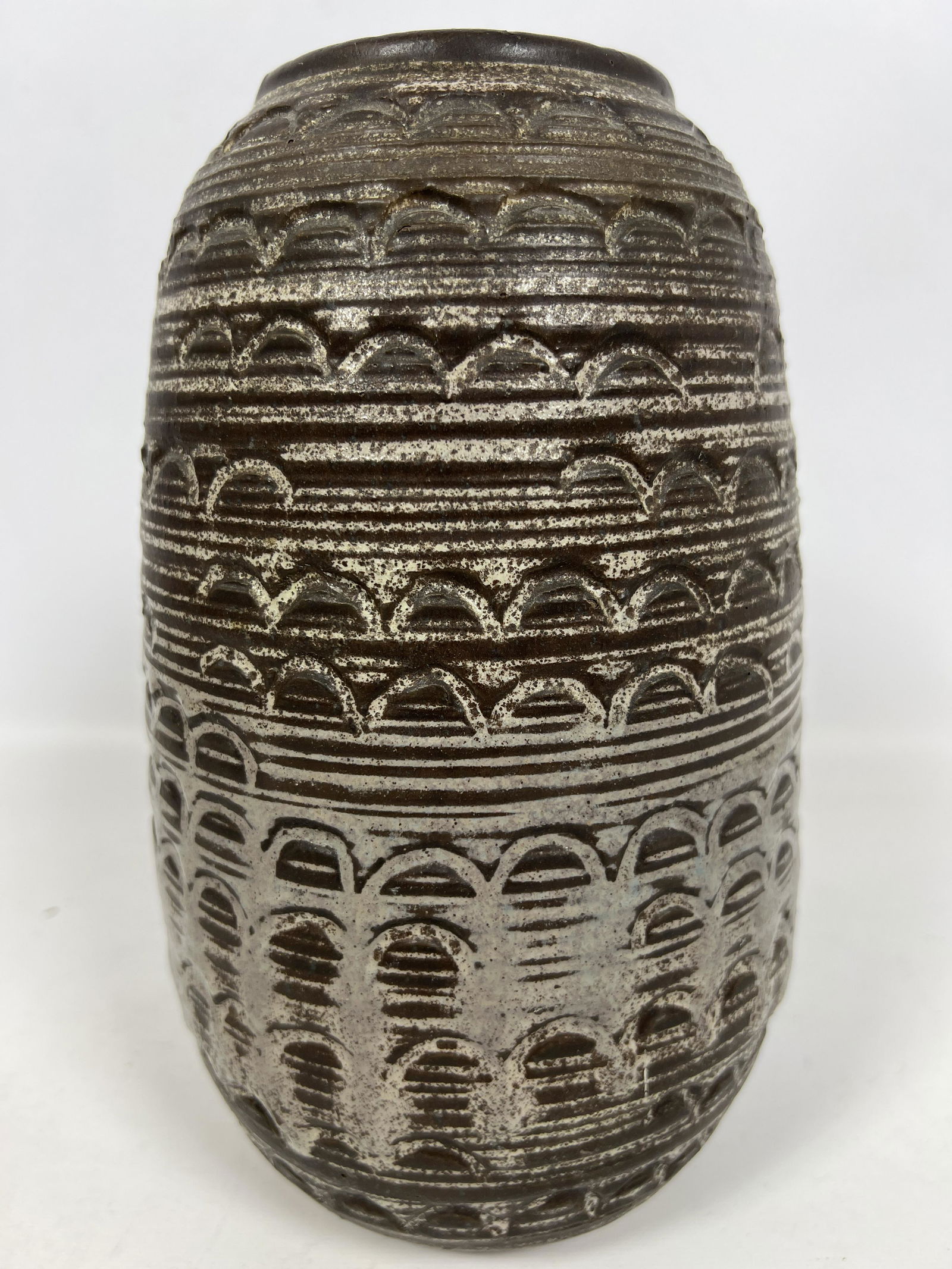 DESIGN TECHNICS Modernist Art Pottery Vase. Incised Relief Arch Design under brown and oatmeal glaze: DESIGN TECHNICS Modernist Art Pottery Vase. Incised Relief Arch Design under brown and oatmeal glazes. Marked. Dimensions: H: 11 inches: W: 4.5 inches: D: 4.5 inches --- Delivery Offer: Uniques offers