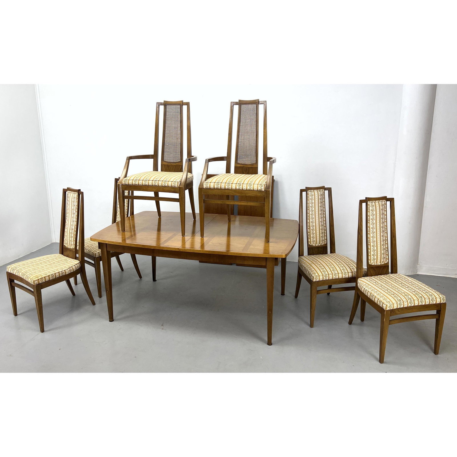 7pc Modernist Dining Table, 6 Chairs. 2 Arm chairs with tall caned backs and 4 Side chairs with upho: 7pc Modernist Dining Table, 6 Chairs. 2 Arm chairs with tall caned backs and 4 Side chairs with upholstered backs. Includes: 2 - 16 inch leaves Dimensions: H: 29.75 inches: W: 66 inches: D: 42 inches